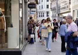 Varios ciudadanos caminan por la calle de Santiago en Valladolid.