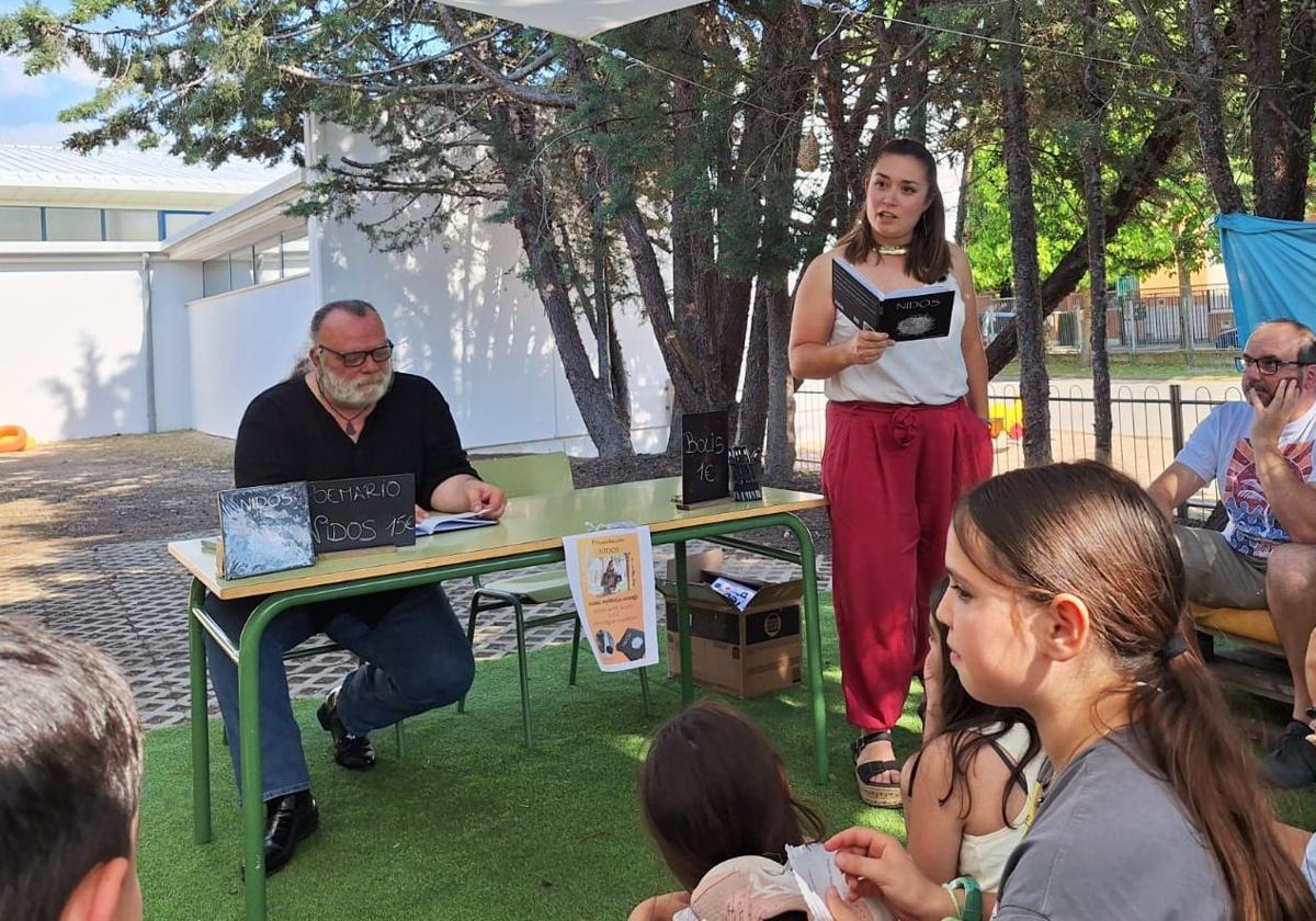 Isabel Sigüenza durante la presentación del libro rodeada de la comunidad educativa. Junto a ella, el poeta Franciso Soto