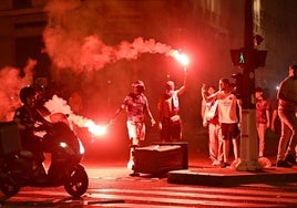 Los hinchas del Paris Saint-Germain (PSG) se reúnen con bengalas en una calle de París.