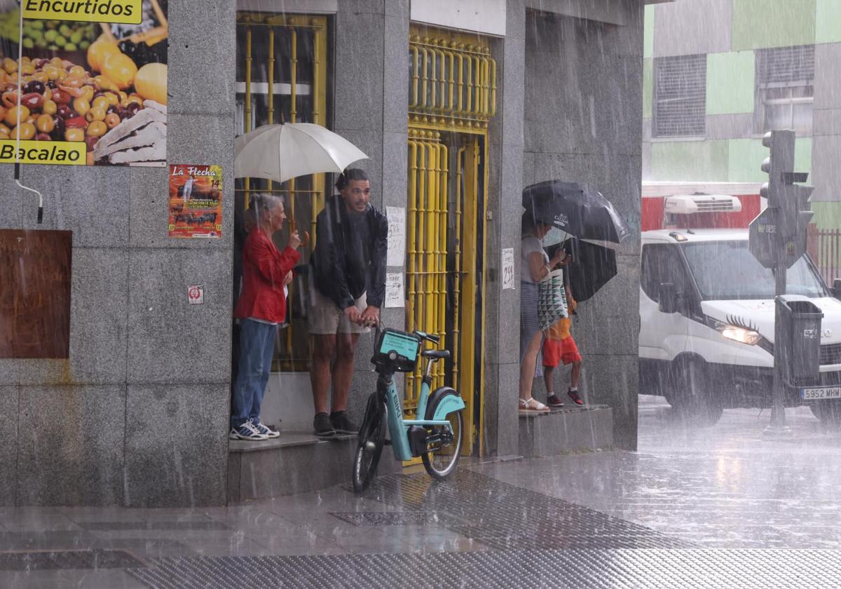 Los vallisoletanos se resguardan de la lluvia en la tormenta del pasado viernes.