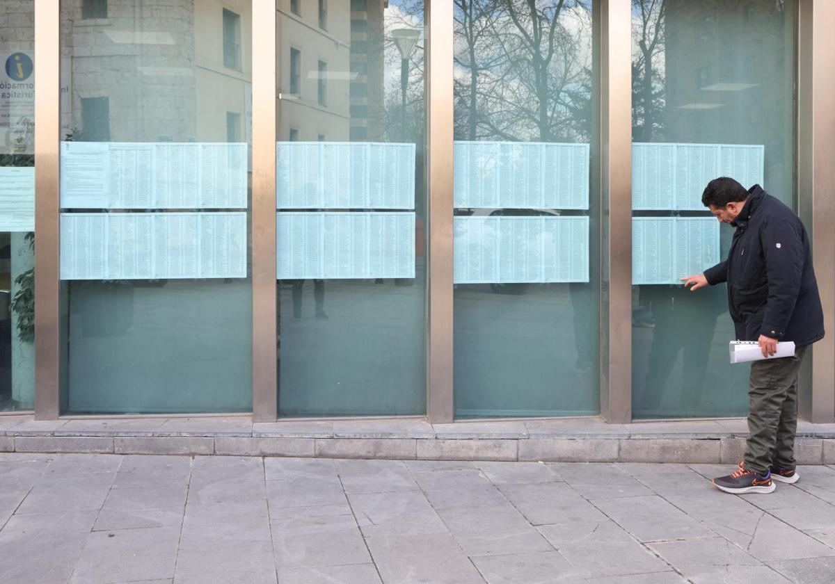 Un hombre mira los nombres de los beneficiados de vivienda pública en la sede de VIVA.