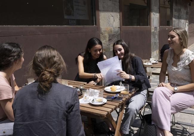 Un grupo de alumnos se toma un café, apuntes en mano, durante un descanso del estudio.