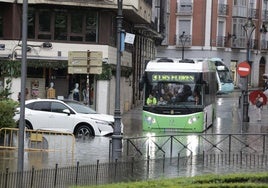 Una autobús y un coche, atrapados por una balsa de agua este martes en Valladolid.