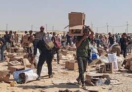 Palestinos recogen lo que queda de suministros de ayuda de la Fundación Humanitaria de Gaza.