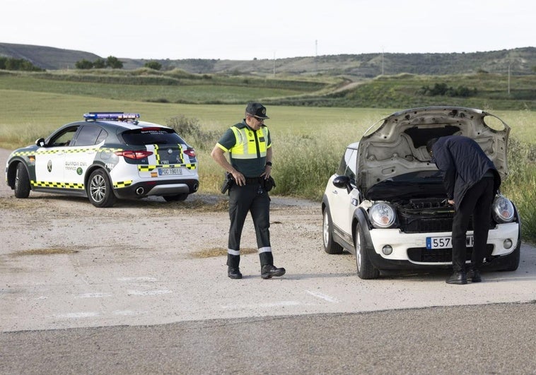Un agente de la Guardia Civil inspecciona un coche tras colisionar con un corzo en Valoria la Buena este jueves.