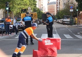 Un operario mueve una pieza de un vallado de plástico en la entrada a Gamazo en presencia de los agentes de la Policía Local.