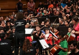 Niños y niñas del proyecto 'Miradas' tocan una pieza junto a músicos de la OSCyL en la sala Sinfónica del Centro Cultural Miguel Delibes.