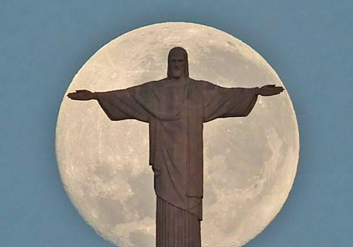 El Cristo Redentor se dibuja delante de la luna llena.