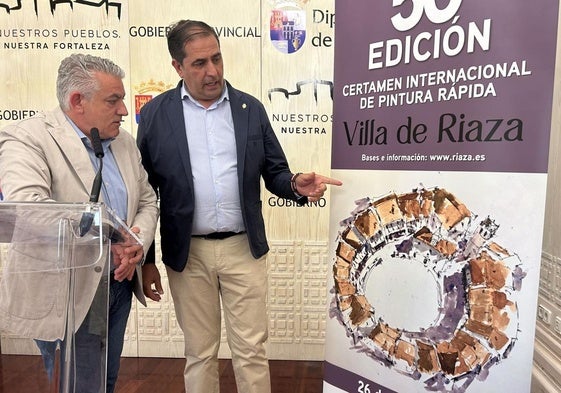 El diputado de Cultura y el alcalde de Riaza muestran el cartel del certamen.