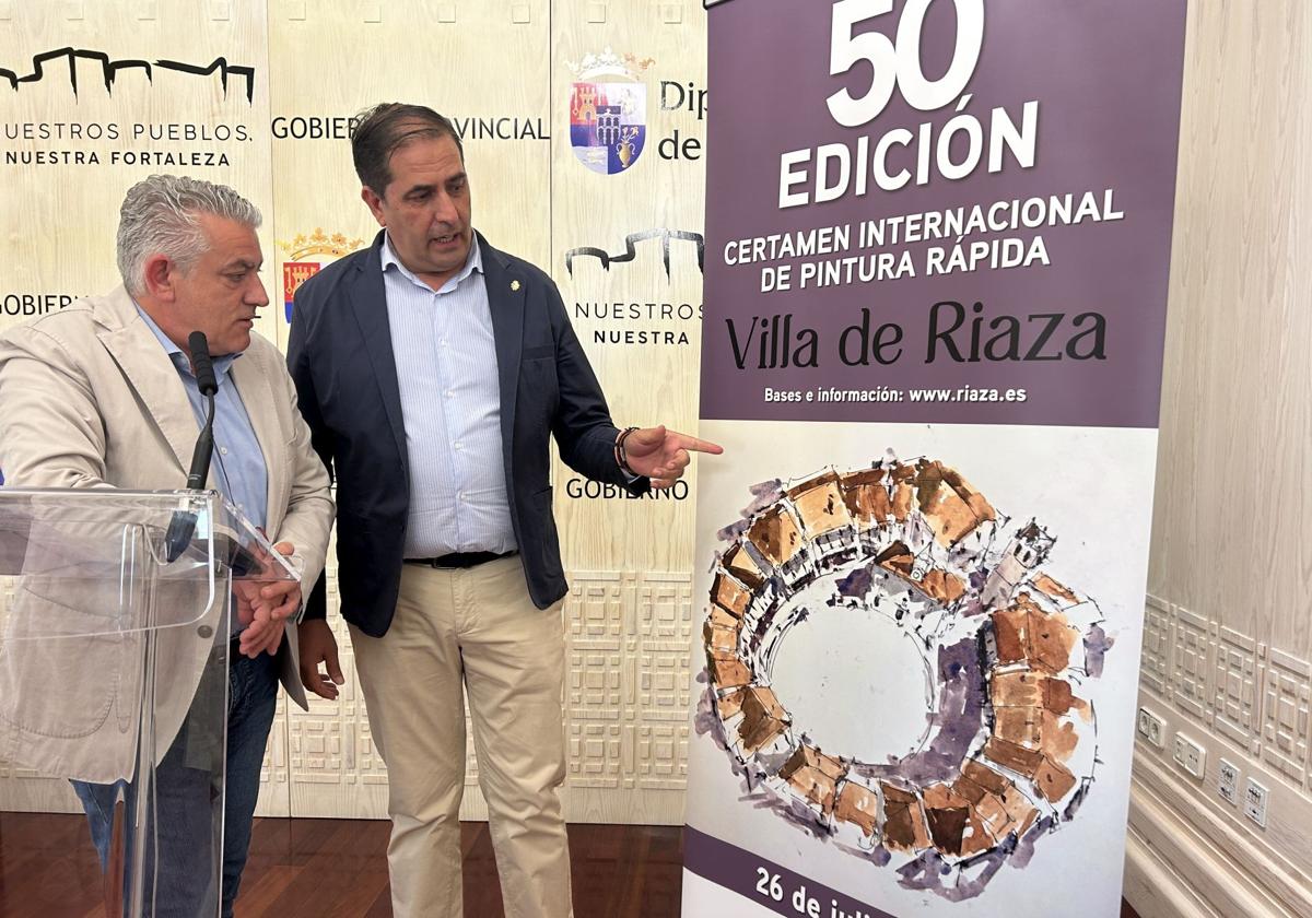 El diputado de Cultura y el alcalde de Riaza muestran el cartel del certamen.