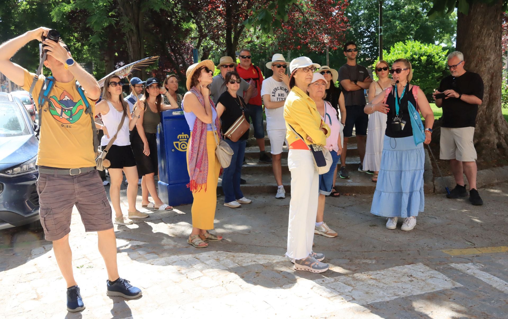 Un grupo de turistas atiende a las explicaciones de una guía en Segovia.