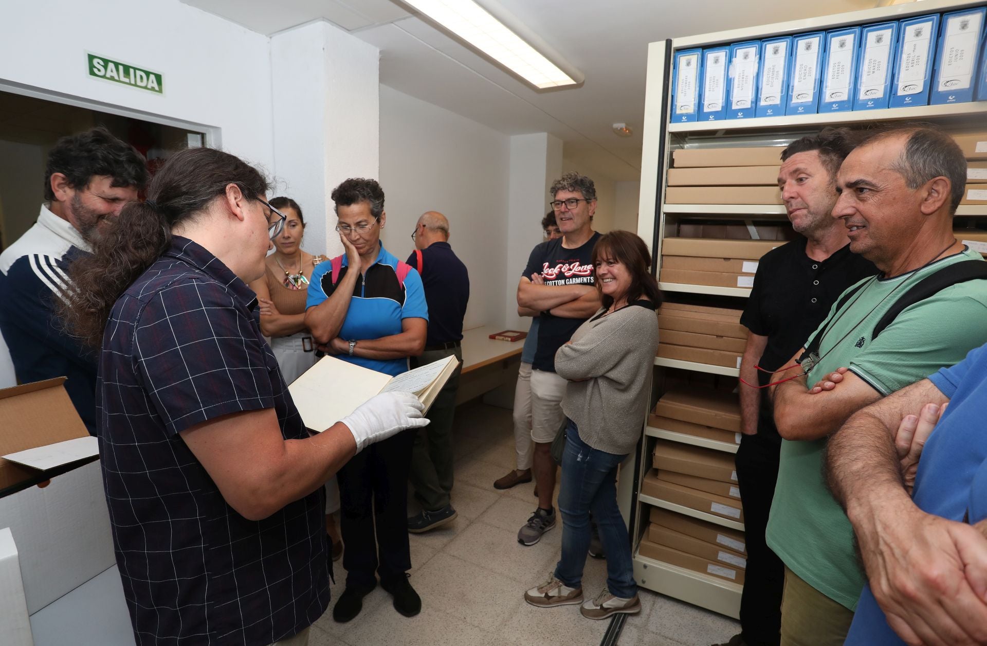 El archivero municipal muestra documentos durante una visita.