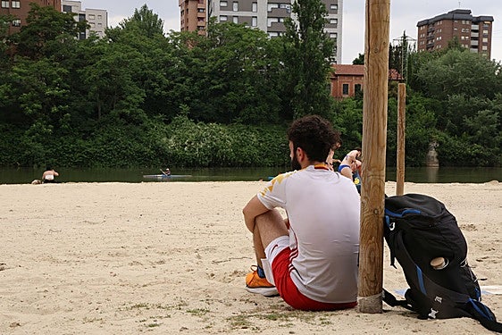 Varias personas disfrutan de la playa fluvial.