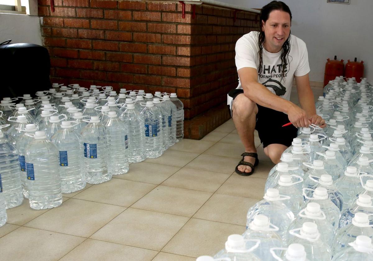 El alcalde de Cabañas de Polendos, Javier Gómez, con las garrafas y botellas de agua para abastecer a la población de Mata de Quintanar.