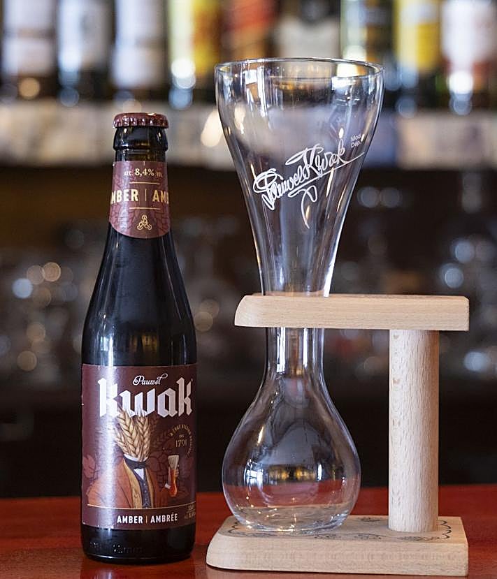 Imagen secundaria 2 - Quique Matilla, sentado junto a la barra del Bar Morgan. En las siguientes imágenes, una exposición de las muchas que acoge el bar de artistas locales, y un vaso y botellín de Kwak, cerveza que el humorista probó por primera vez en el Morgan.