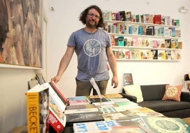 Carlos Rod, en la editorial La Uña Rota, junto a mucho de los títulos publicados.