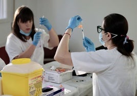 Dos enfermeras prepara las dosis de vacunación de gripe y covid en una imagen de archivo.