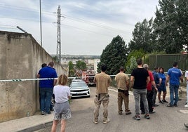 Trabajadores y vecinos observan las labores de extinción desde el precinto de la Guardia Civil.
