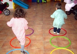 Dos pequeños juegan en un aula.