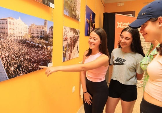 Tres chicas comentan una de las fotografías de la exposición.