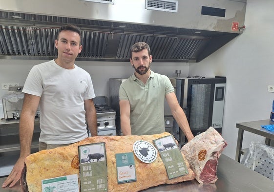 Carlos y Borja, en la cocina de Gohi´s, junto a un chuletero de carne de vaca de trabajo
