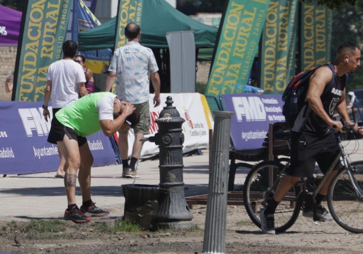 Un vallisoletano se refresca en una fuente este sábado 28 de junio.