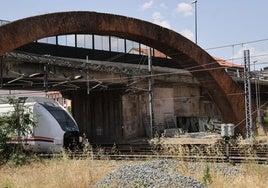 Andamios preparados para su montaje junto al vano del viaducto por el que pasa el tren.