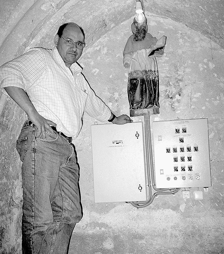 Carlos Gallego junto al cuadro electrónico de mandos que activa automáticamente las campanas y el reloj de la iglesia de San Miguel Arcángel de Villalón. 17 de junio de 2001.