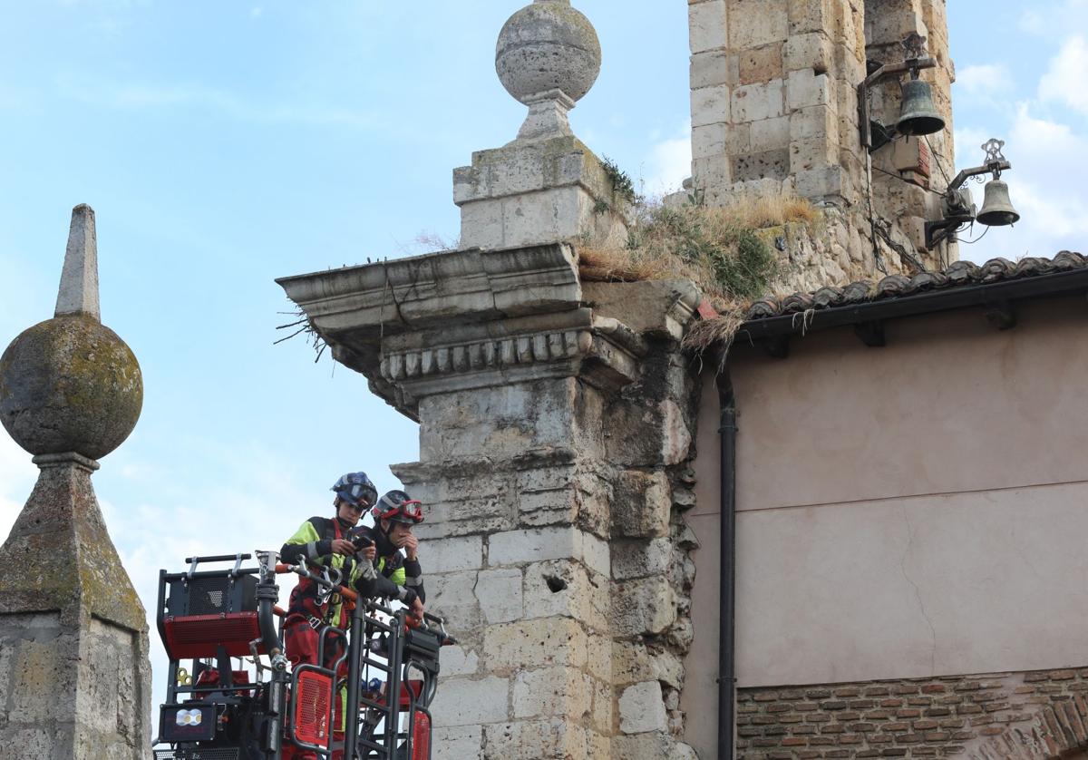 Los bomberos comprueban el estado de la espadaña, tras el desprendimiento.