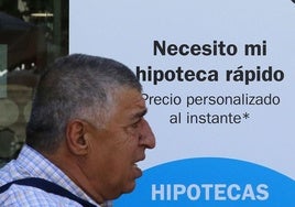 Un hombre pasa junto a un anuncio de un producto hipotecario de un banco en Segovia.