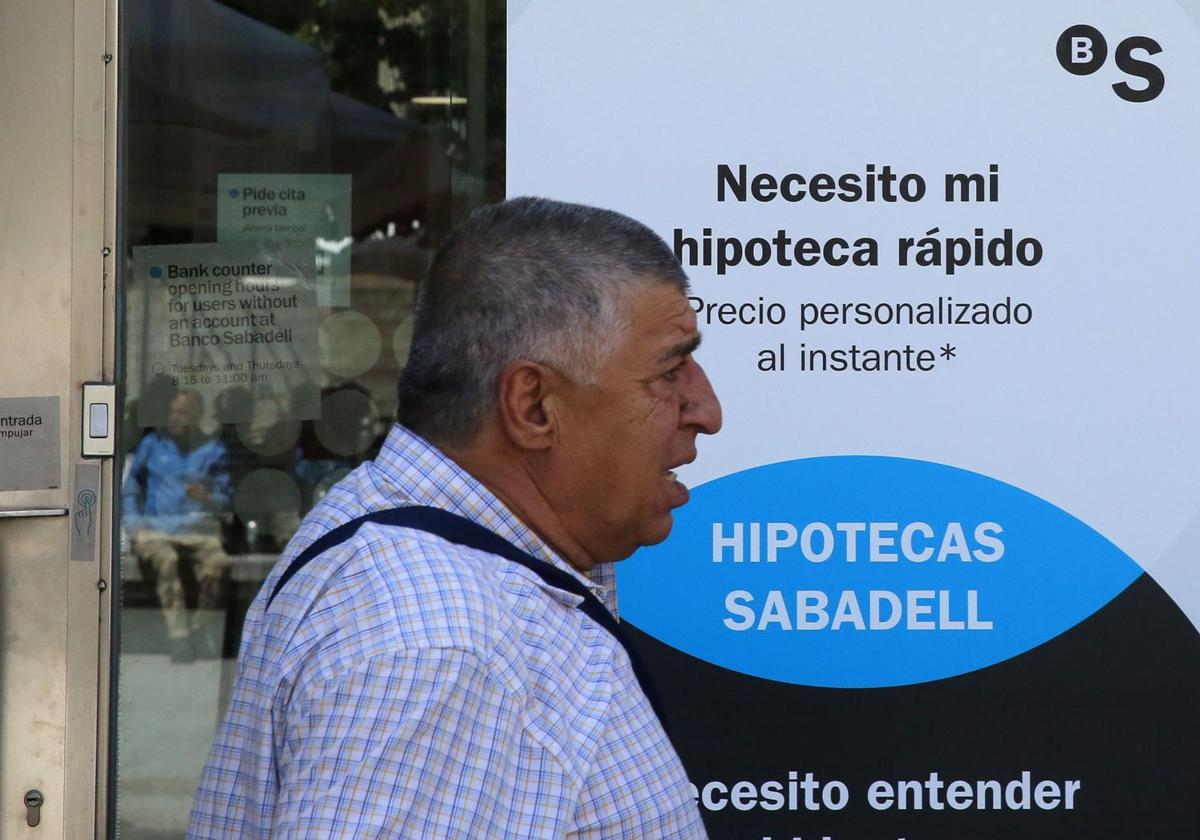 Un hombre pasa junto a un anuncio de un producto hipotecario de un banco en Segovia.