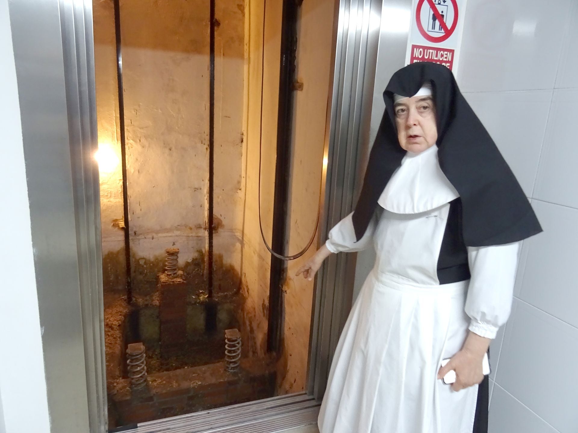 Una monja del asilo San José señala los desperfectos ocasionados por la fuerte tromba de agua caída en Medina del Campo.