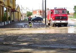 Un bombero limpia la calle tras la tromba que anegó Medina del Campo