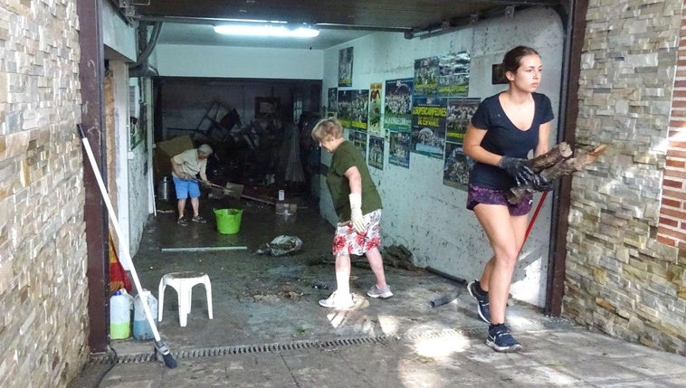 Residentes y familiares sacan los enseres afectados por la tromba que anegó una vivienda de la calle Obispo Barrientos de Medina del Campo.