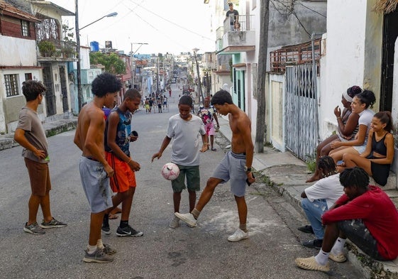 Jóvenes con un balón en una calle de La Habana.
