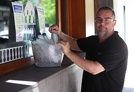Gonzalo Soriano, del restaurante Niza, prepara su punto de hidratación en la esquina de las calles Padilla y Empecinado.