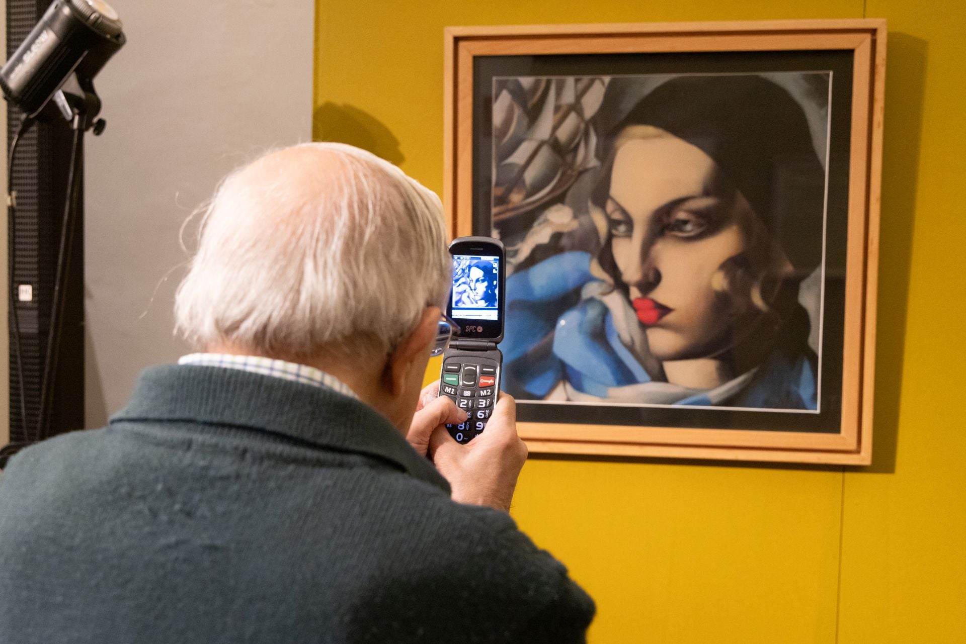 Un hombre fotografía la impresión en seda de 'L'echarpe bleue', de Tamara de Lempicka.
