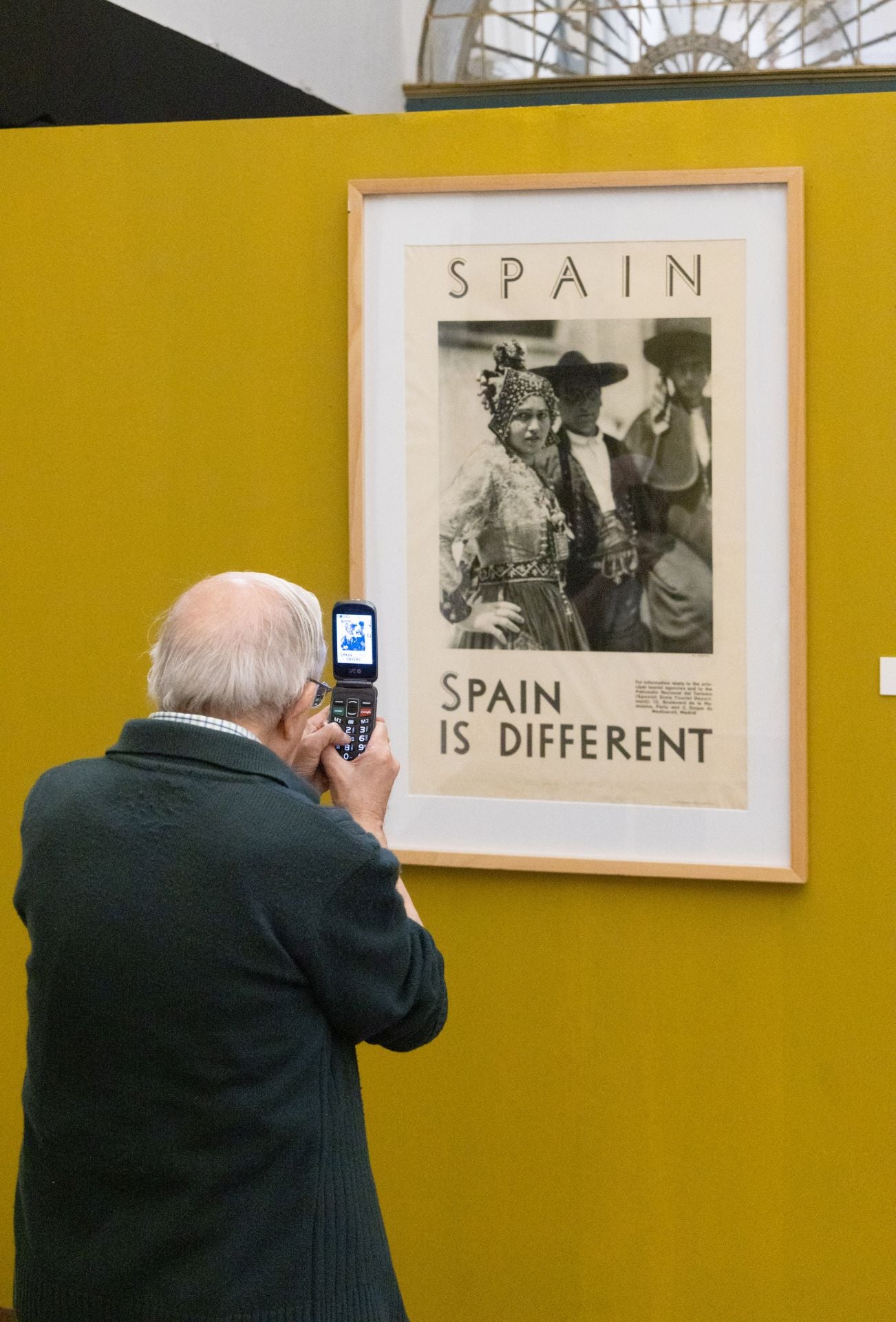 Un hombre fotografía la impresión en seda de 'L'echarpe bleue', de Tamara de Lempicka.