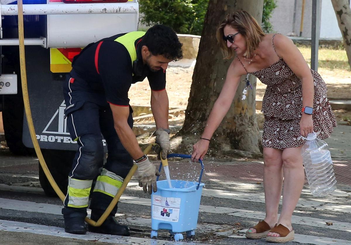 Una mujer recoge agua, este miércoles, de un camión nodriza de los Bomberos de Segovia en la plaza Centro Segoviano.