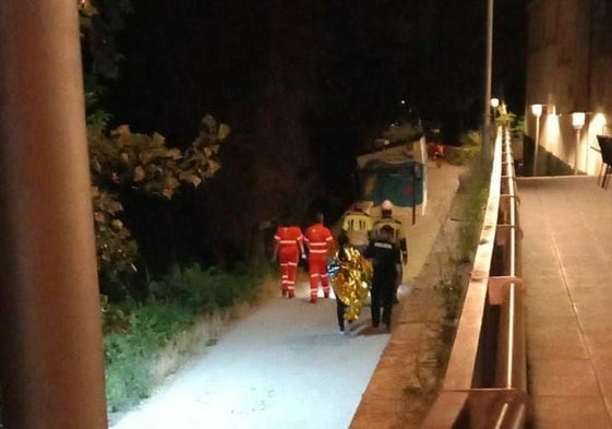 Los bomberos, junto al joven tras sacarlo de río.
