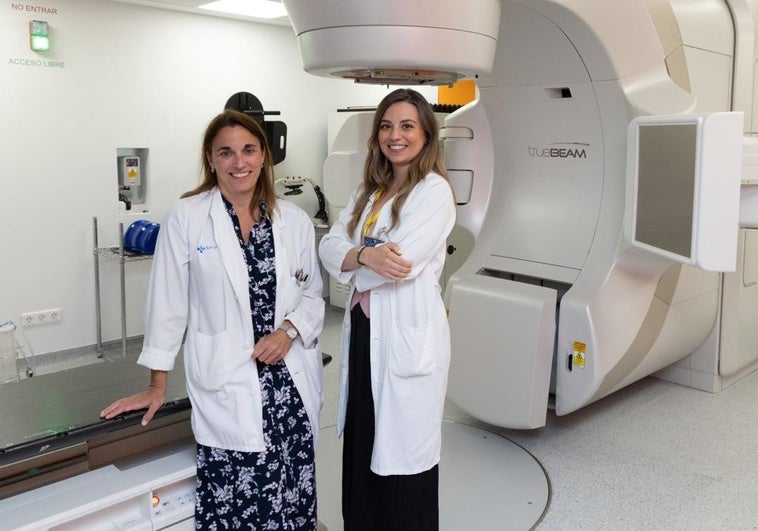 Las doctoras Patricia Diezhandino García, jefa del Servicio de Oncología Radioterápica del Hospital Clínico Universitario de Valladolid, y Patricia Valencia Nieto, especialista de ese servicio, ante uno de los aceleradores lineales del centro.