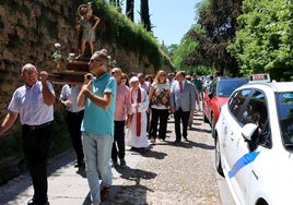 La procesión en honor a San Cristóbal pasa junto a un taxi.