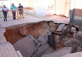 Tres personas observan el socavón en Rodilana, localidad cercana a Medina del Campo, tras las tormentas del 4 de julio.