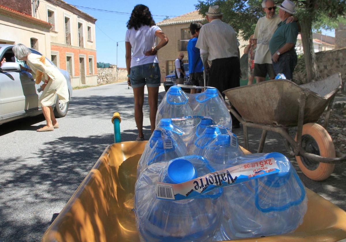 Imagen de archivo de unos vecinos llevando botellas de agua en un pueblo de Segovia.
