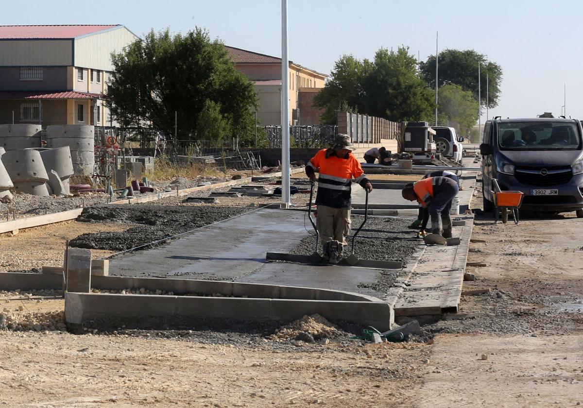 Operarios trabajan este jueves en el acerado de la urbanización del polígono de Los Hitales, en Bernuy de Porreros.