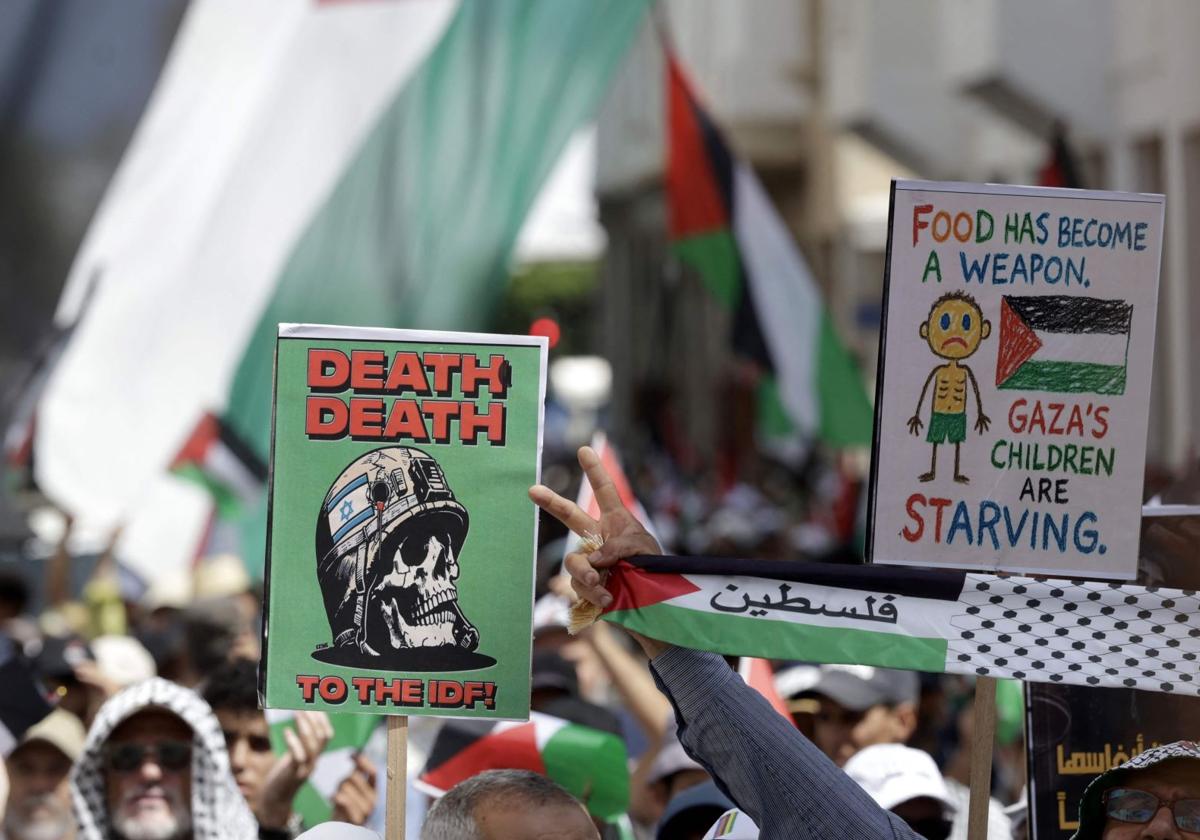 Marroquíes ondean pancartas y la bandera palestina durante una marcha en Rabat para expresar su solidaridad con los palestinos en la Franja de Gaza.