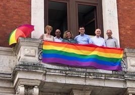 Los concejales del PSOE exhiben la bandera LGTBI desde el balcón de su grupo municipal en el Ayuntamiento.