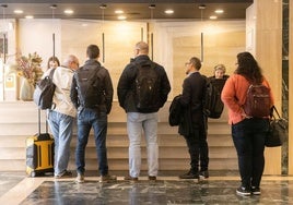 Clientes de un hotel vallisoletano cumplimentando gestiones en la recepción del establecimiento.