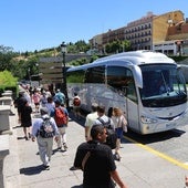 Personas pasean por Vía Roma junto a varios autobuses turísticos.