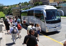 Personas pasean por Vía Roma junto a varios autobuses turísticos.
